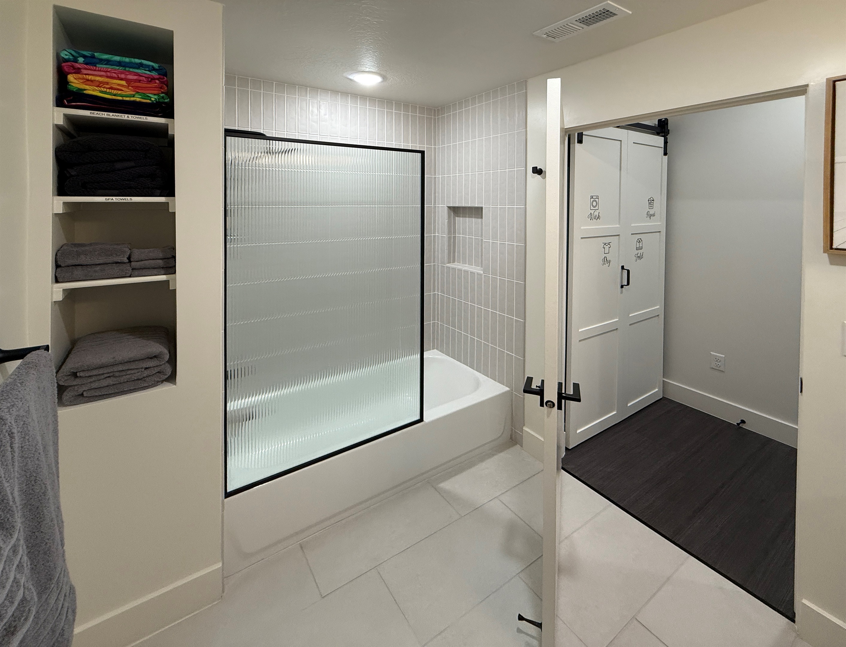 Experience the spacious tub and shower combo enclosed with a sleek glass door.