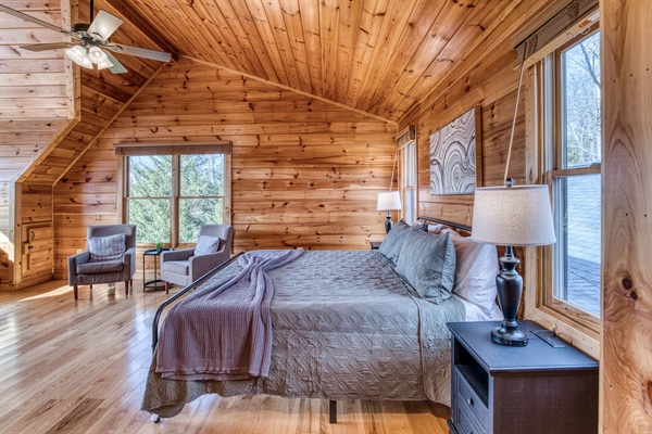 One of the 2 upstairs bedrooms, both with a king bed, private bathroom, and sleeping nook sitting in a huge window with stunning mountain views!