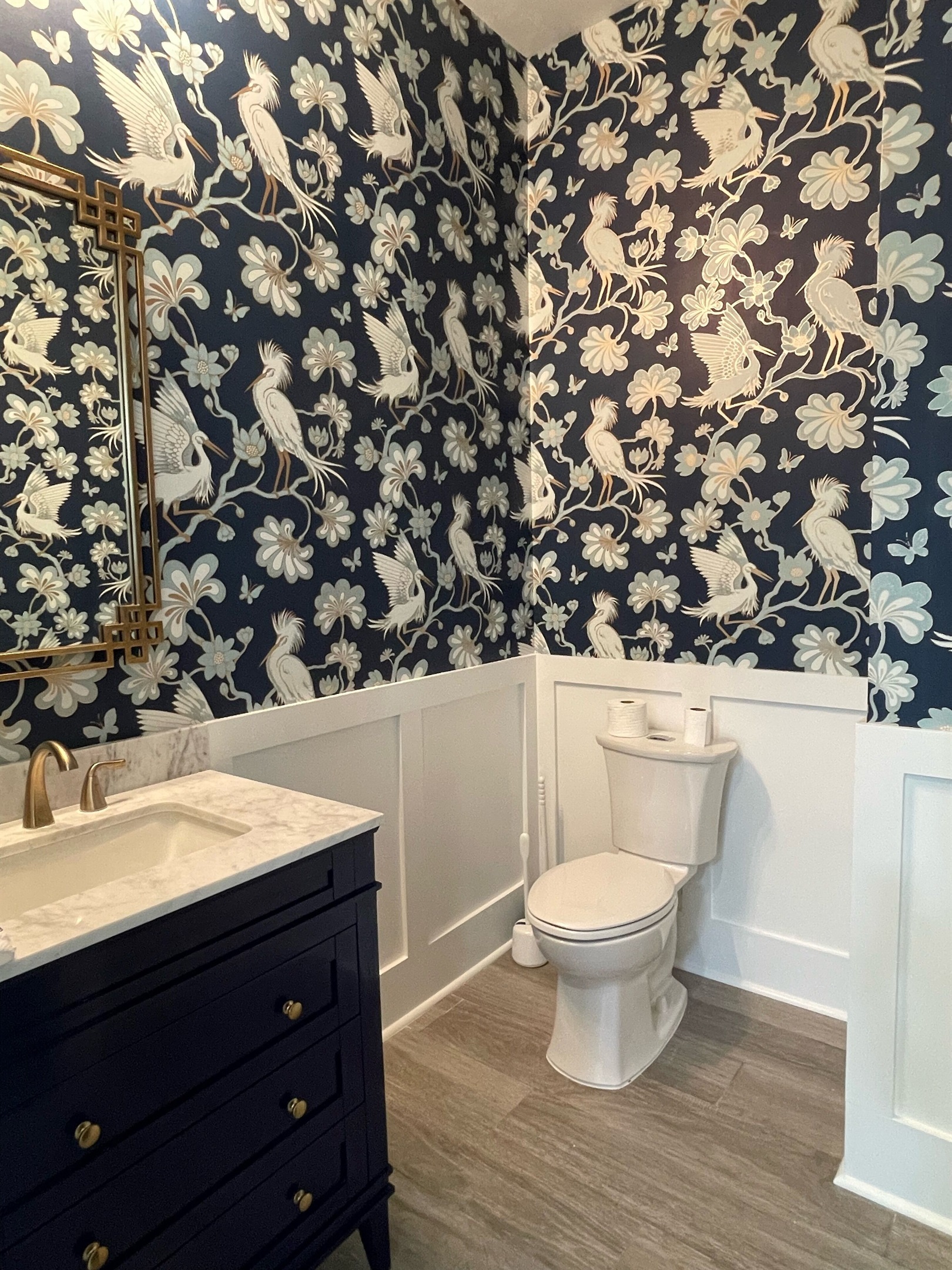 Newly enlarged powder room on main floor with beautiful tropical wall paper 