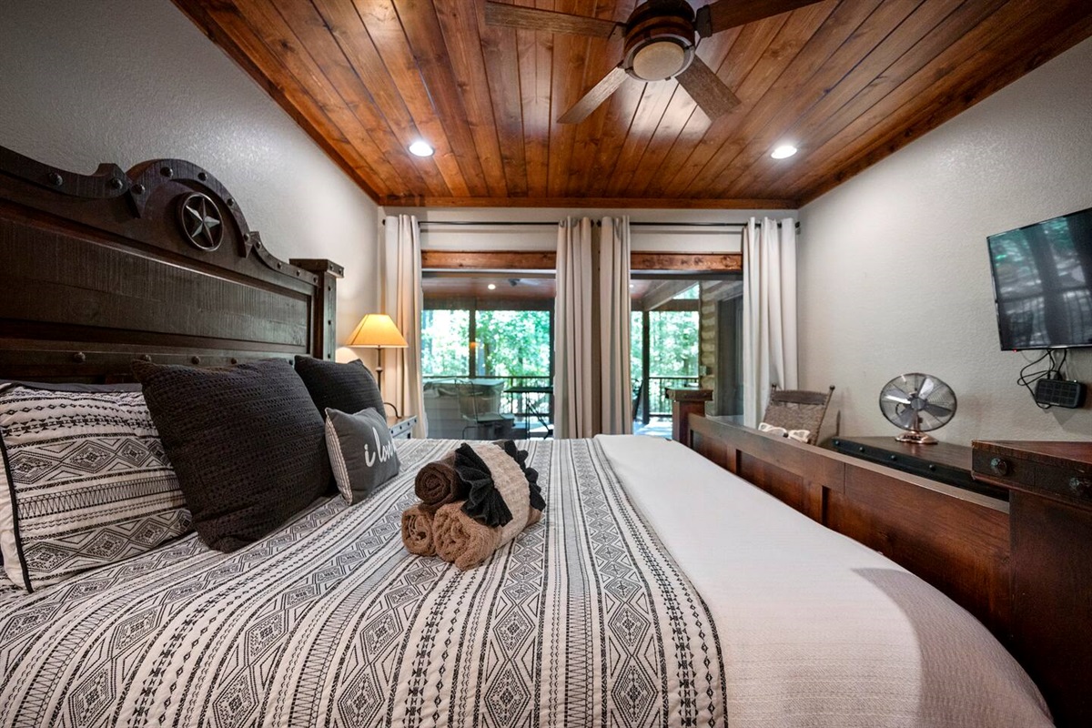 A comfortable bed, ceiling fan and black out curtains for a good night's rest