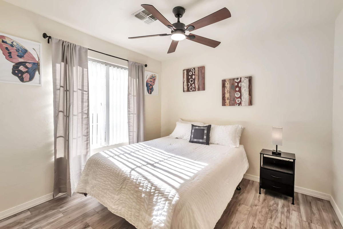 Second bedroom, same comfort — a restful bed, ceiling fan, and a quiet corner to recharge