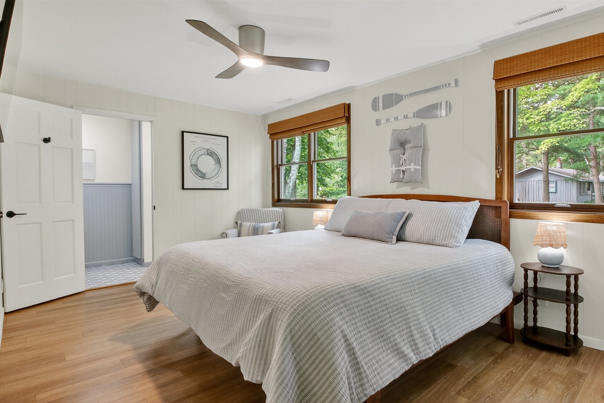 Enjoy privacy in the primary bedroom bedroom with en-suite bathroom, Roku TV, king-sized bed, and closet for clothing storage.