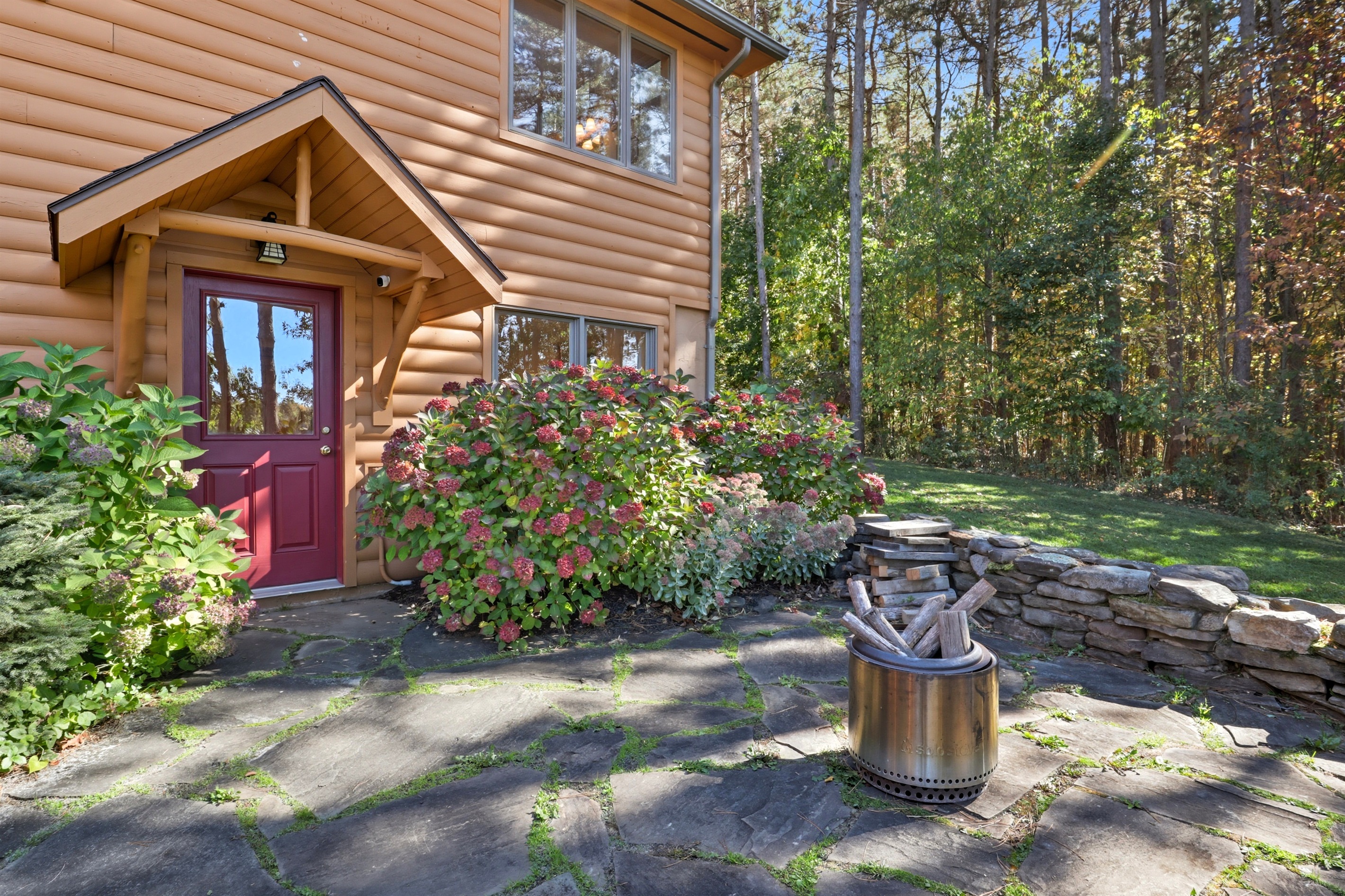 Charming cabin exterior with lush landscaping and cozy firepit for evenings under the stars.