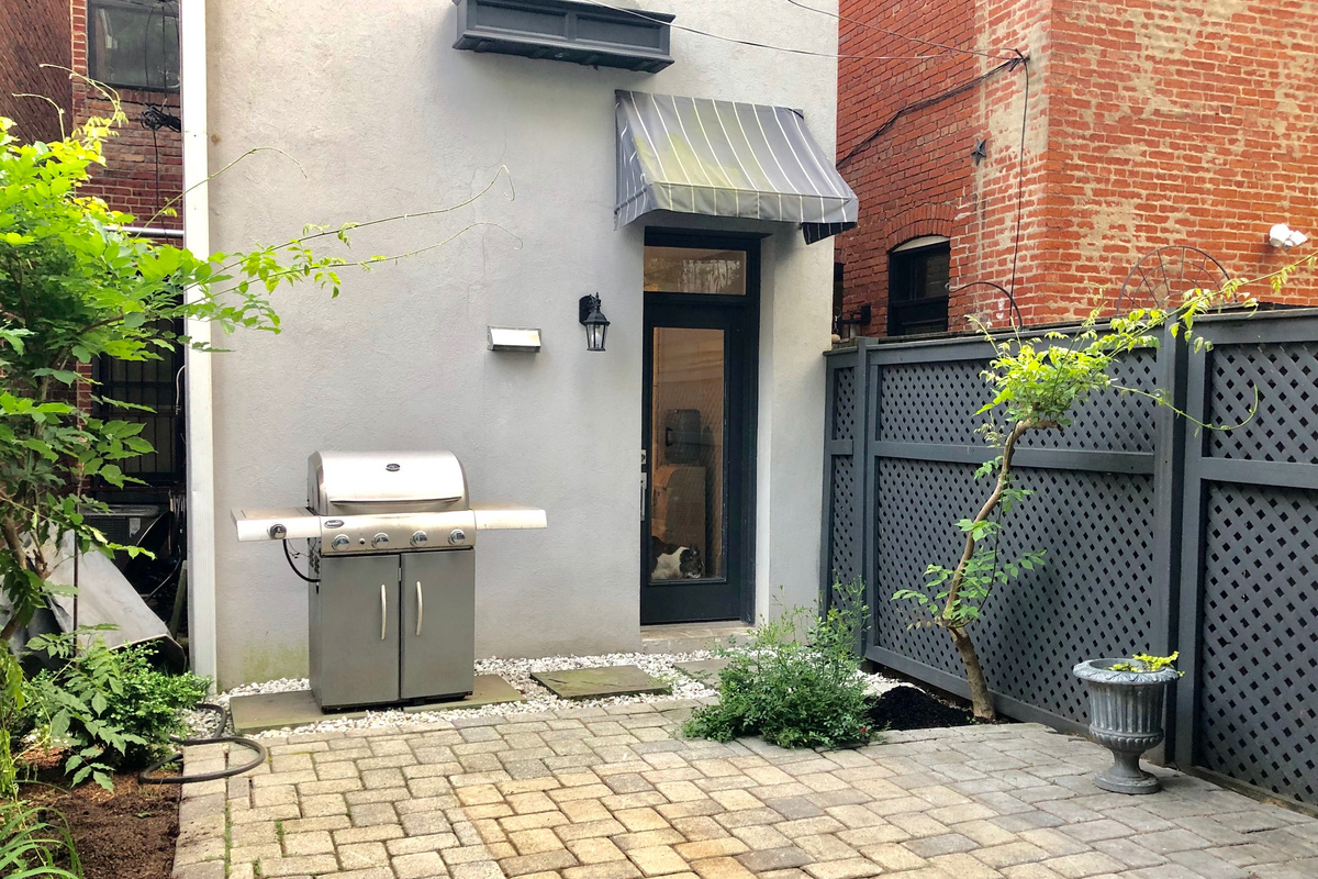 Private fenced patio with a full-size gas grill—perfect for outdoor meals, quiet mornings, or evening hangs.