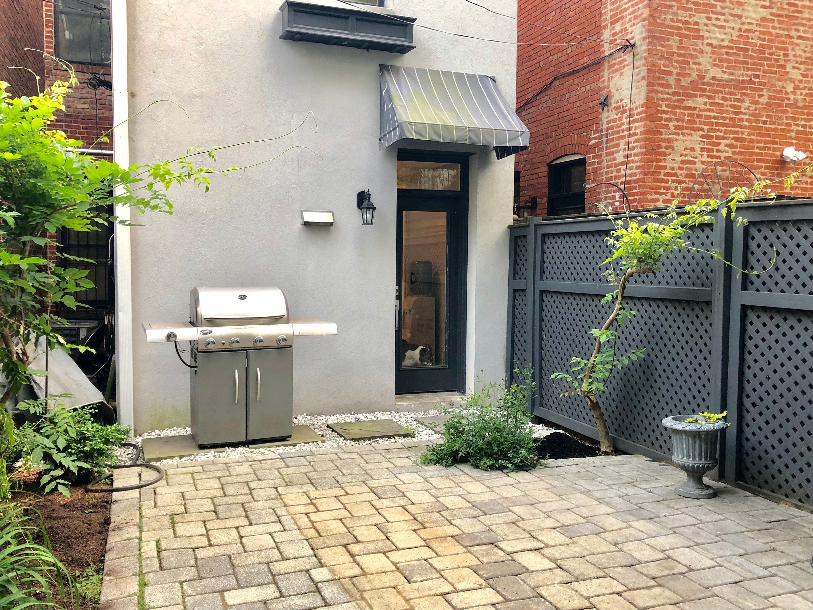 Private fenced patio with a full-size gas grill—perfect for outdoor meals, quiet mornings, or evening hangs.