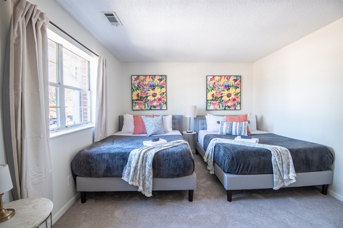 This bedroom has two queen beds with plush bedding and a calm, welcoming feel for relaxing evenings to unwind and begs for late mornings.