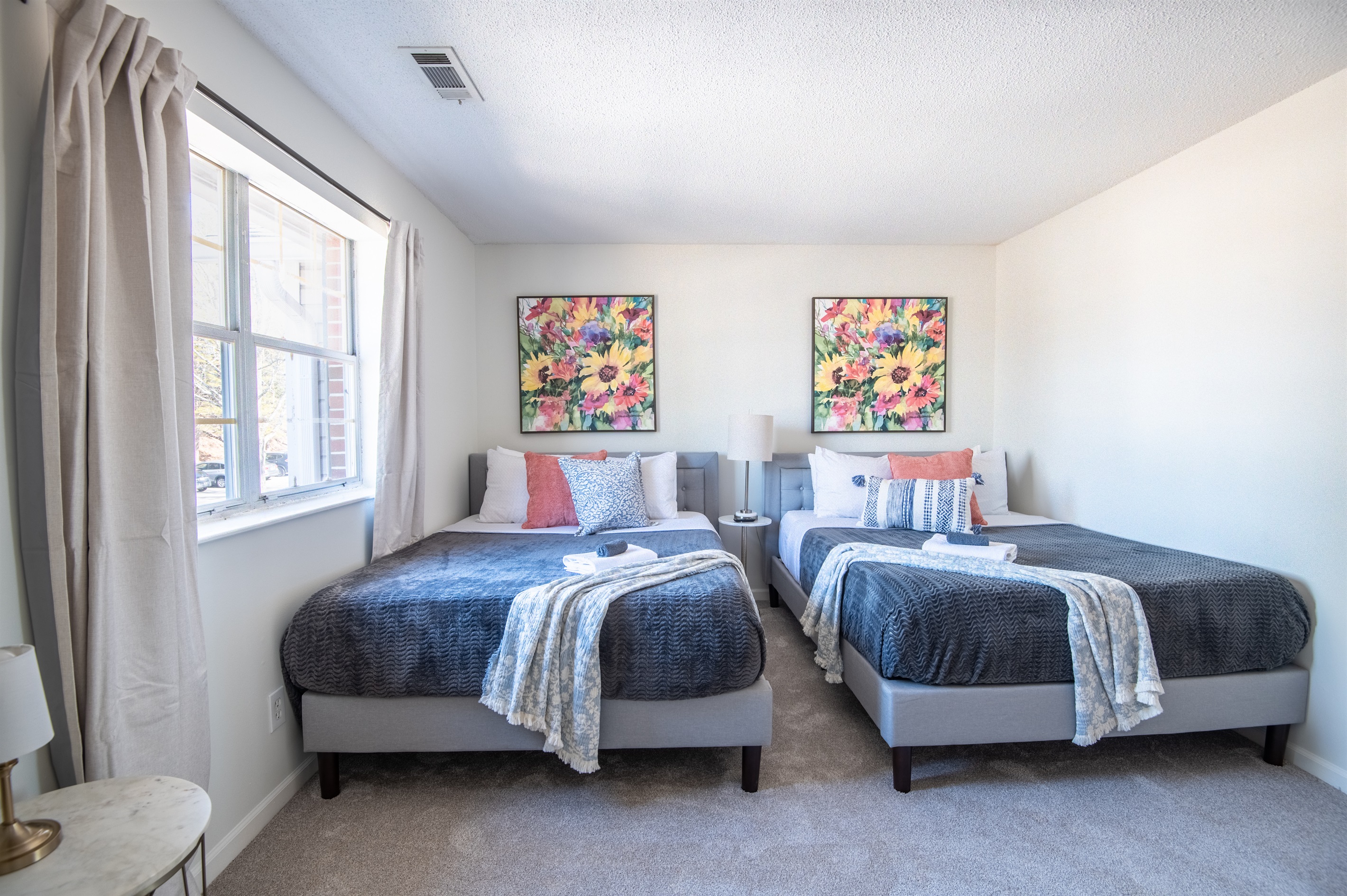 This bedroom has two queen beds with plush bedding and a calm, welcoming feel for relaxing evenings to unwind and begs for late mornings.