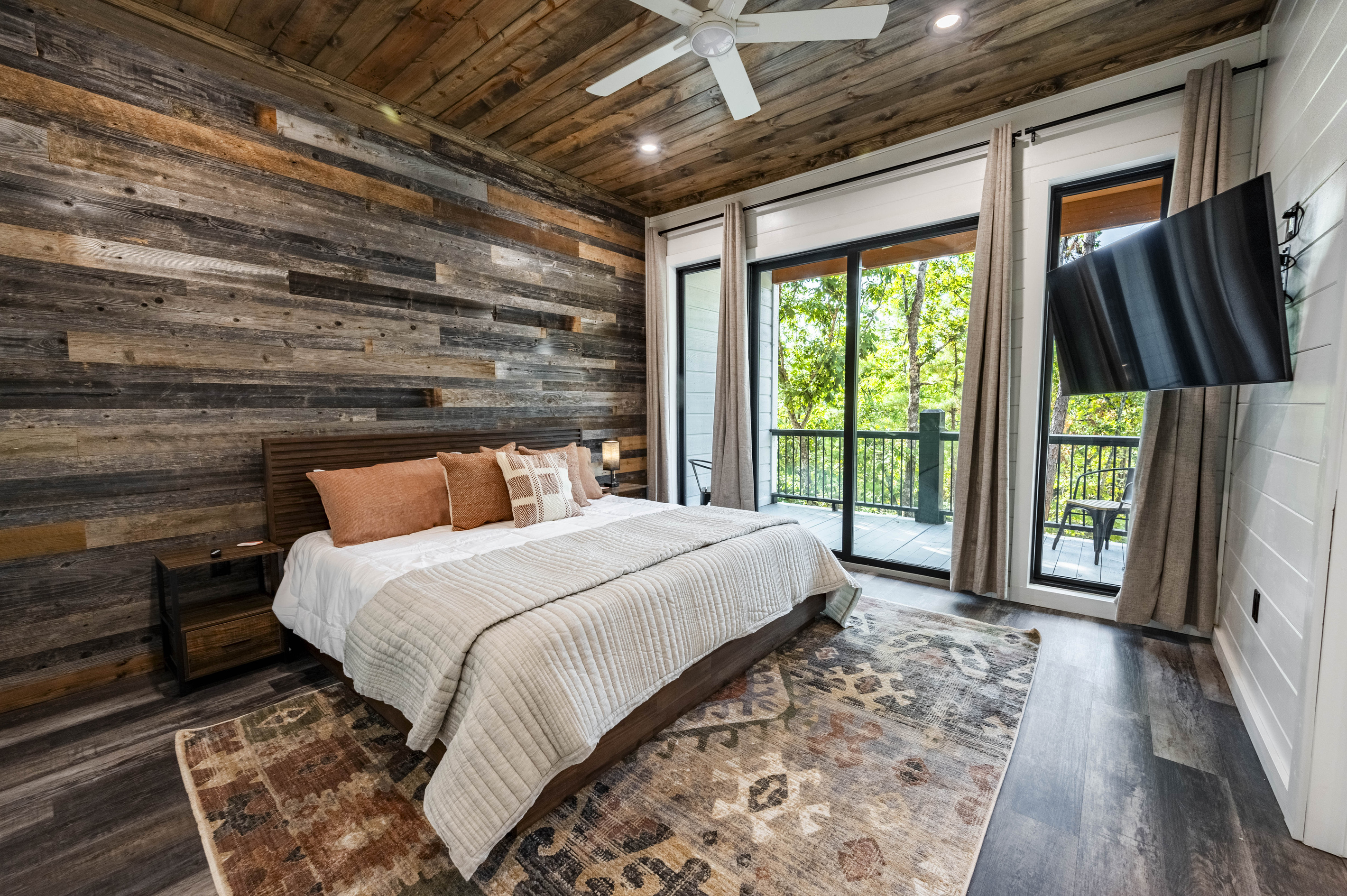 Bedroom designed with an inviting decor, cozy bedding and large windows with an attached patio to step out and enjoy nature!