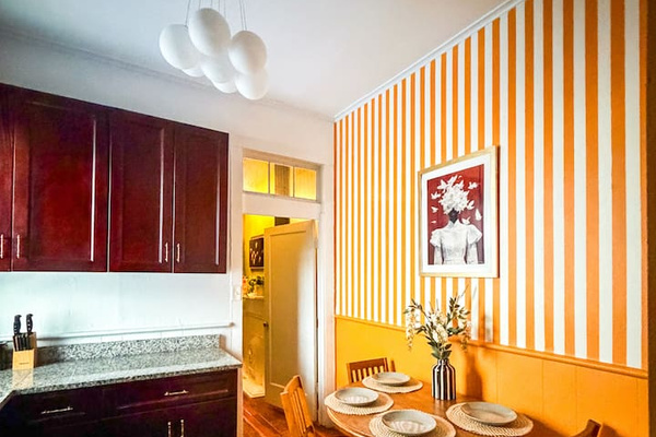 Bright kitchen and dining space with playful striped walls and seating for group meals. Fully  equipped for cooking, coffee, and brunch before exploring the French Quarter. And dining for 6 people! 