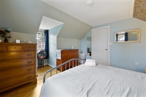 Bed footers point of view with beautiful window and dressers