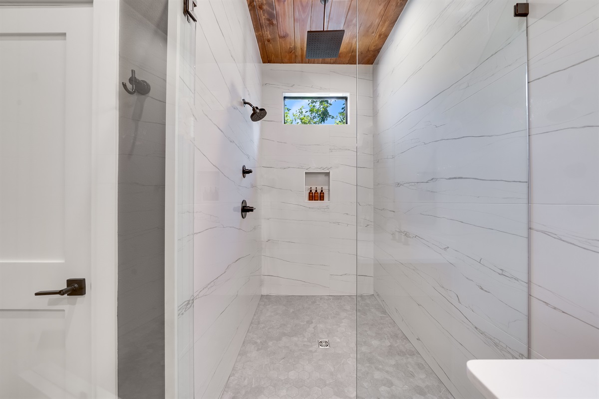 Ensuite Bathroom 1 - Private bathroom attached to King Suite 1. Featuring oversized shower with dual showerheads and spa-quality marble finishes. Includes premium toiletries (body wash, shampoo, conditioner, hand soap) and hotel quality towels. 