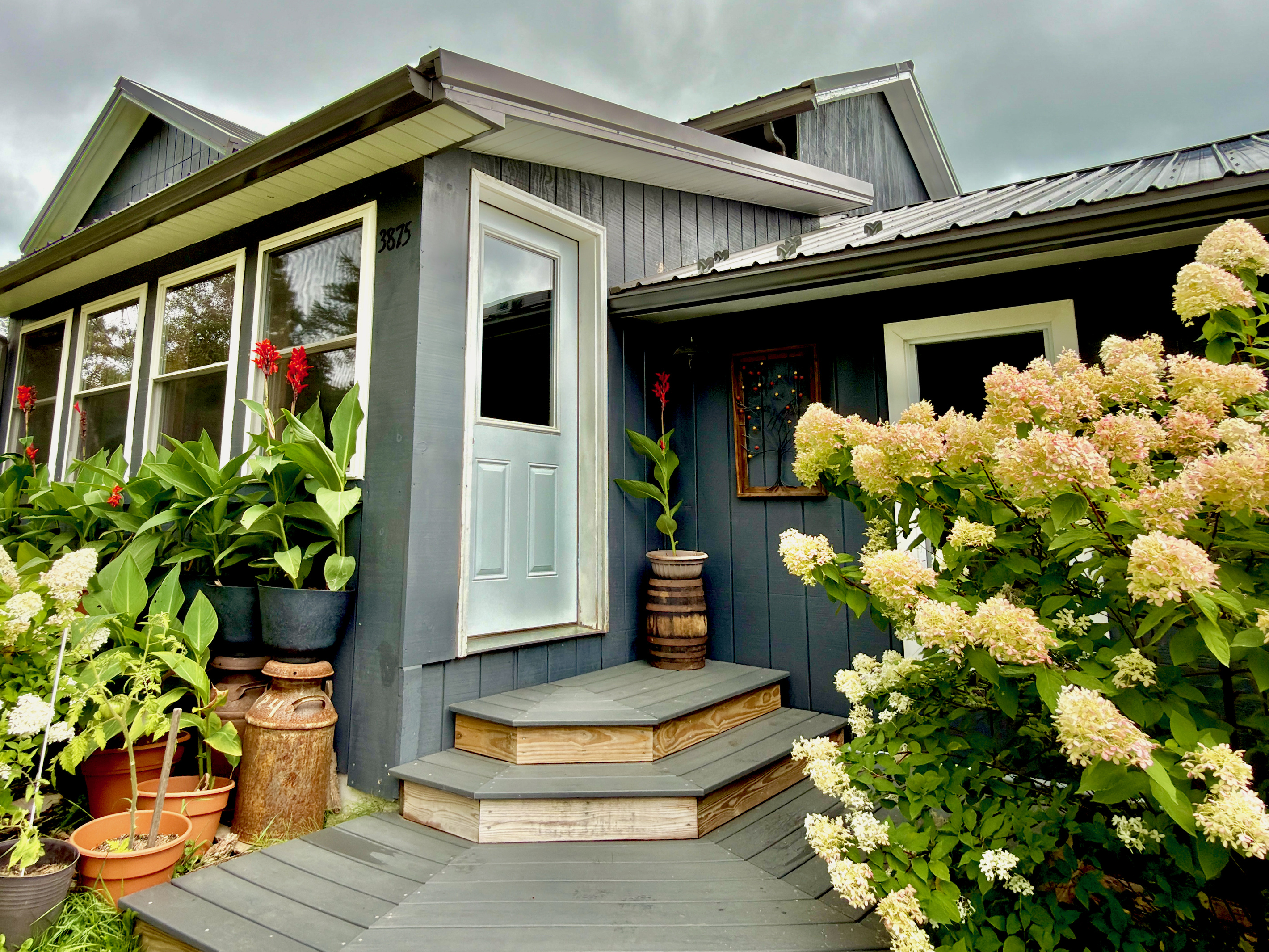 Main entrance framed by hydrangeas and our hummingbird café. This scenic view is best enjoyed from our dining area. You’ll find the lockbox conveniently located here for your arrival.