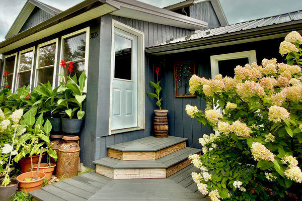 Main entrance framed by hydrangeas and our hummingbird café. This scenic view is best enjoyed from our dining area. You’ll find the lockbox conveniently located here for your arrival.