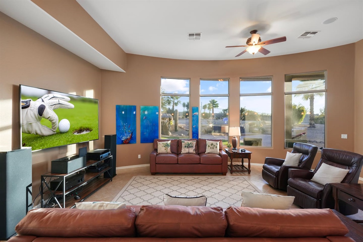Comfortable living area with oversized windows and views of the private backyard oasis