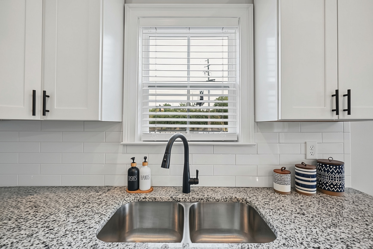 Deep double sink with a window view, dishes and hand soap provided