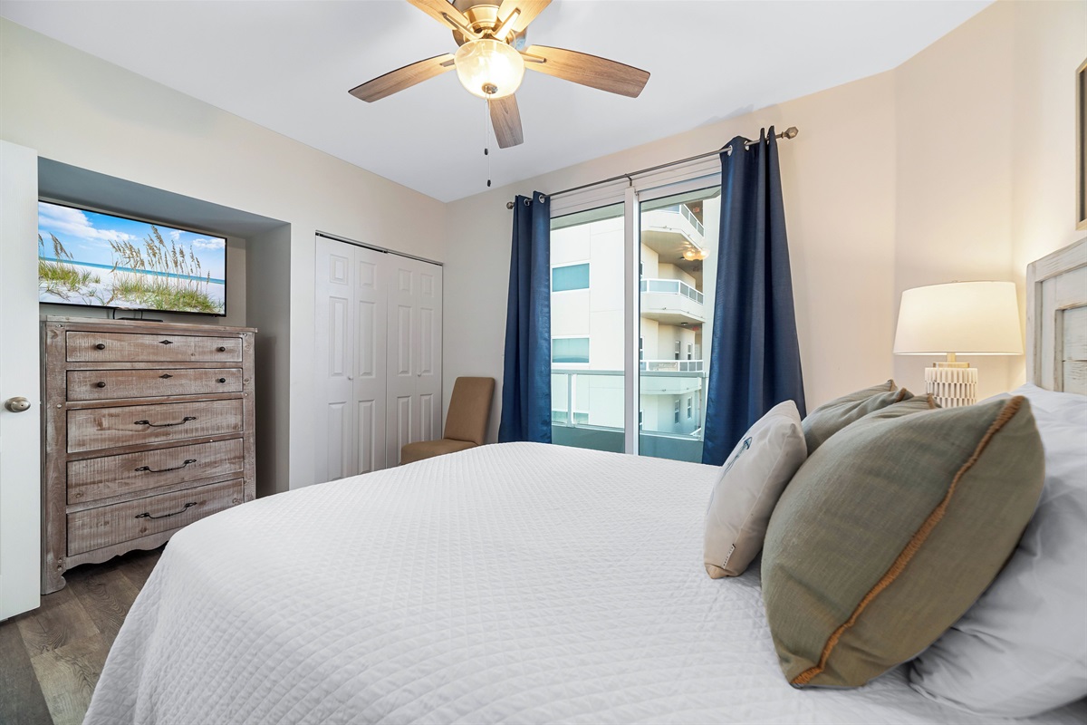 Bedroom 2 with king bed, ceiling fan and direct balcony access