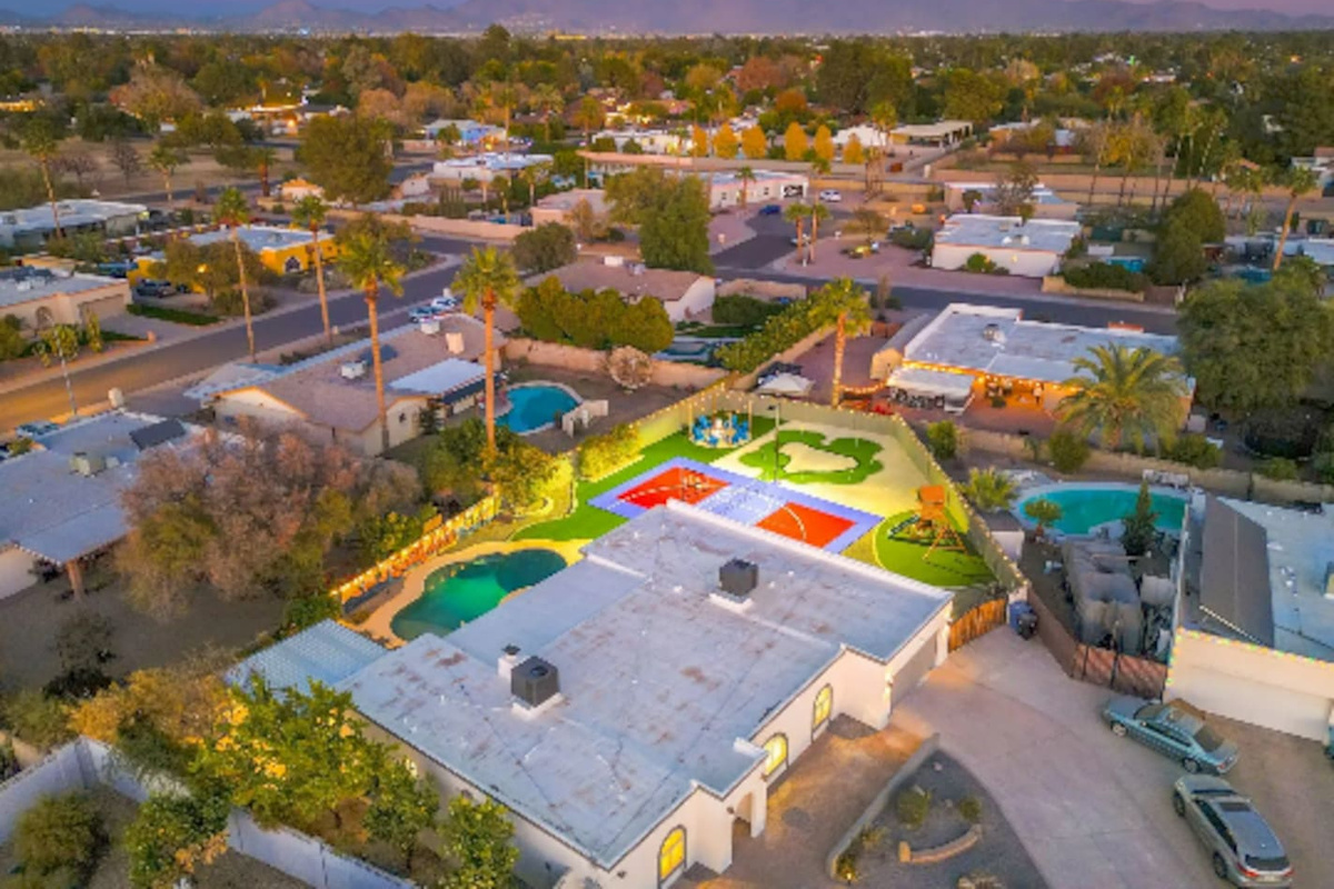 A backyard built for a crowd: pool, sport court, and putting green, all on one oversized lot.