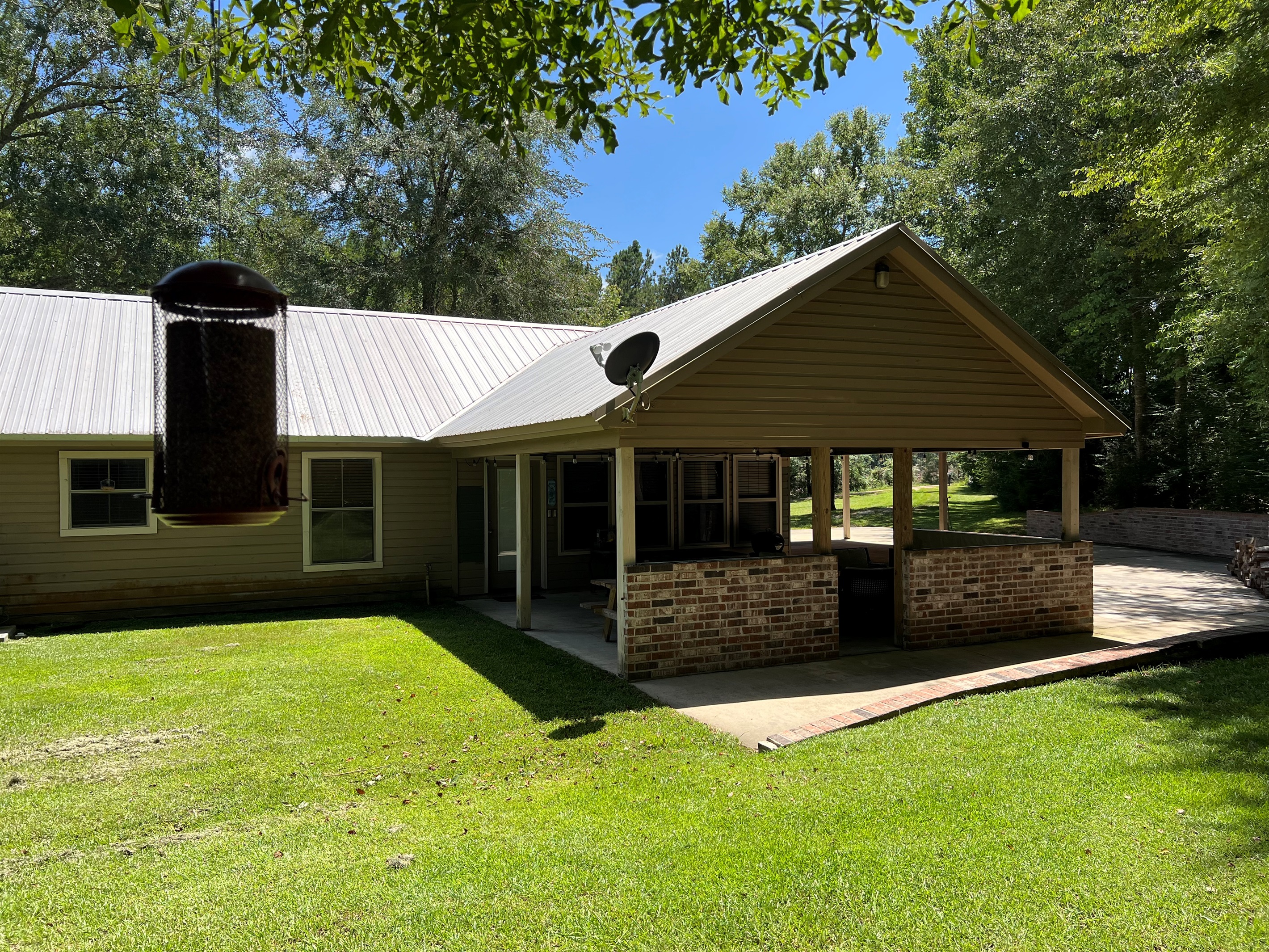 Back patio opens up large backyard 
Great for sitting in the shade while the kids or pets play in the cleared 1 Acre yard