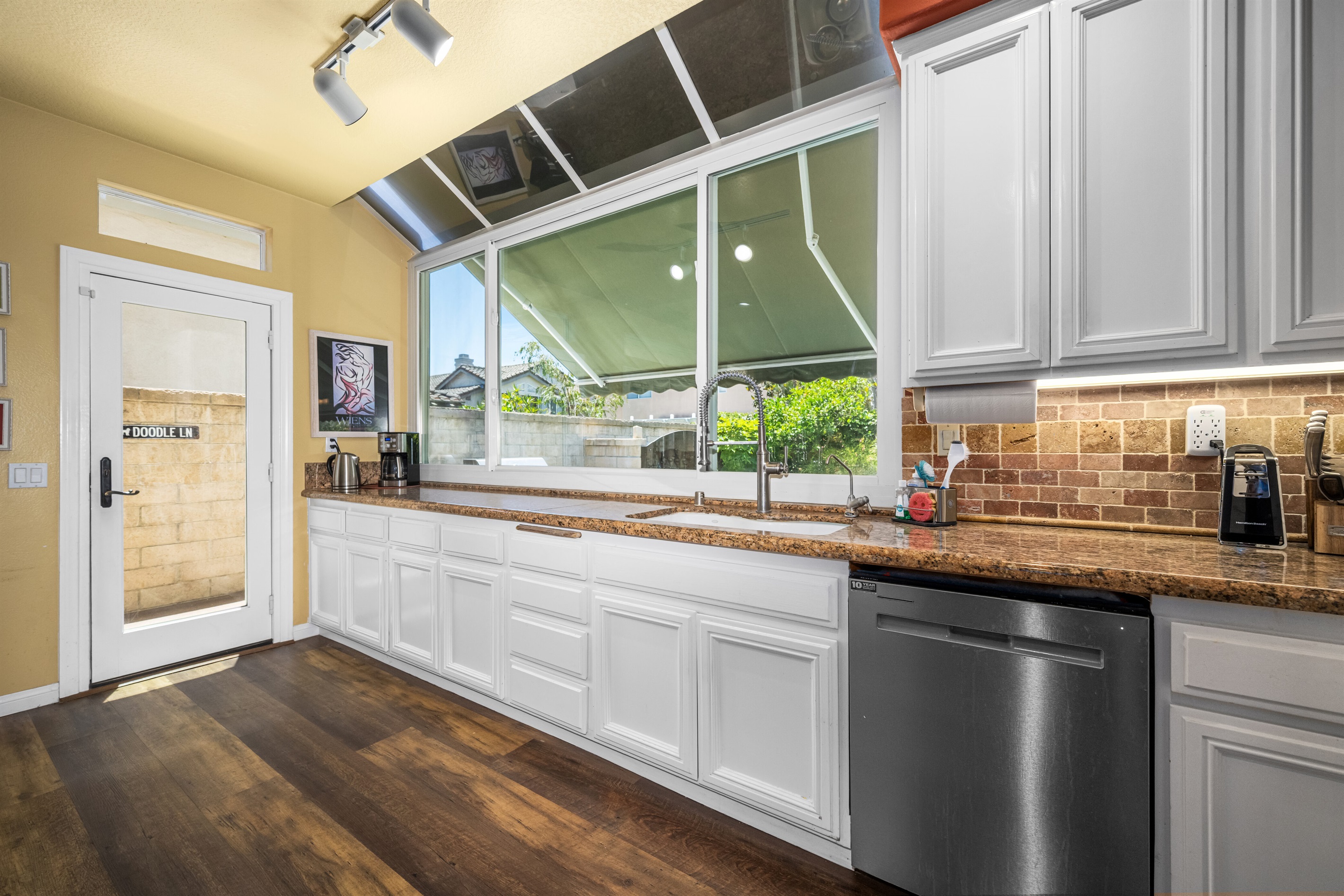 Kitchen door, opens to “Doodle Lane” dog run.