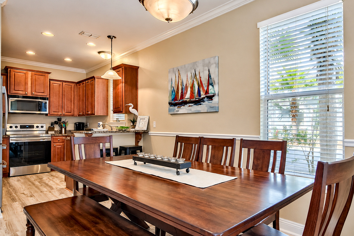 Spacious dining area featuring a large 8–9-seater coastal table, with a kitchen bar for two.