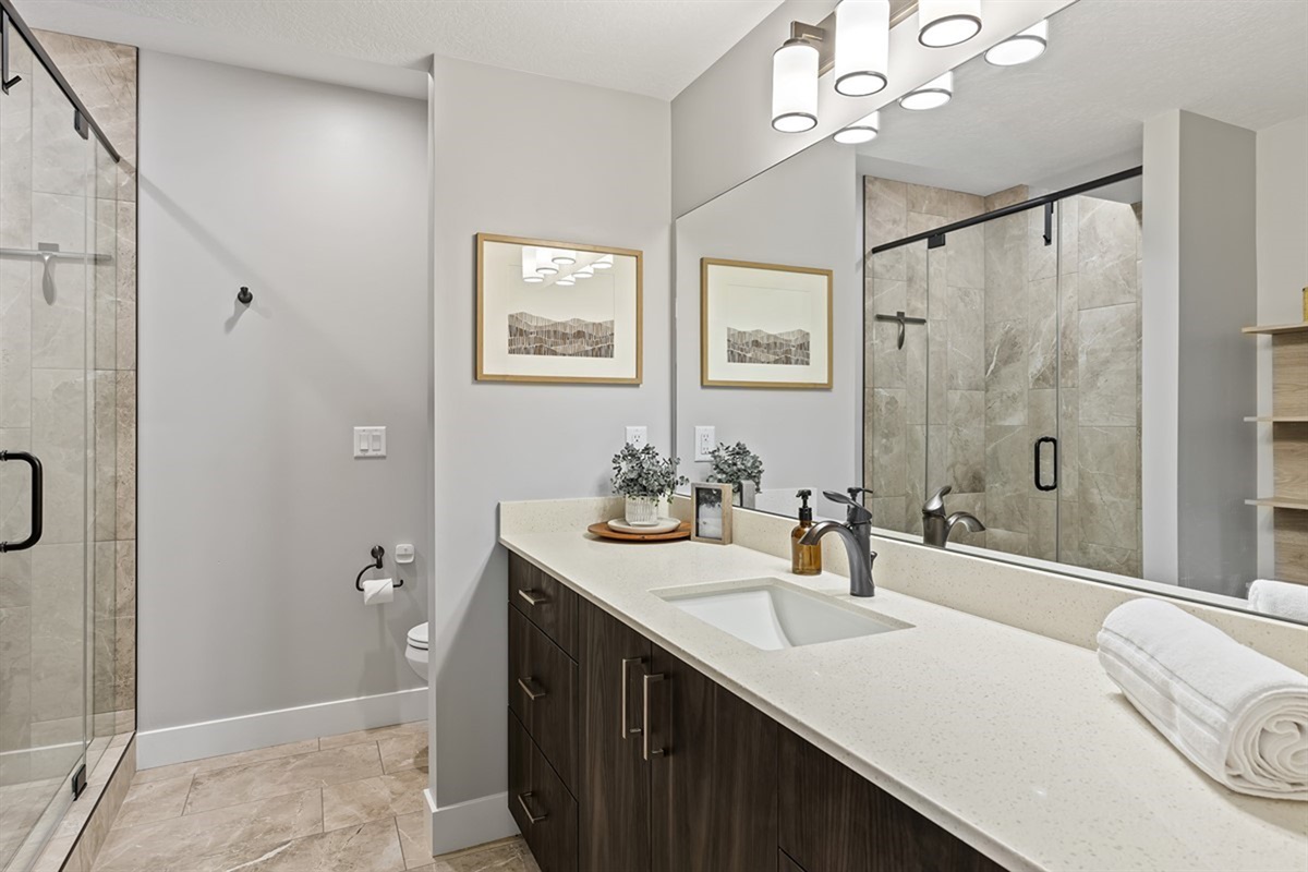 Spa-style bathroom with dual vanity and large walk-in glass shower