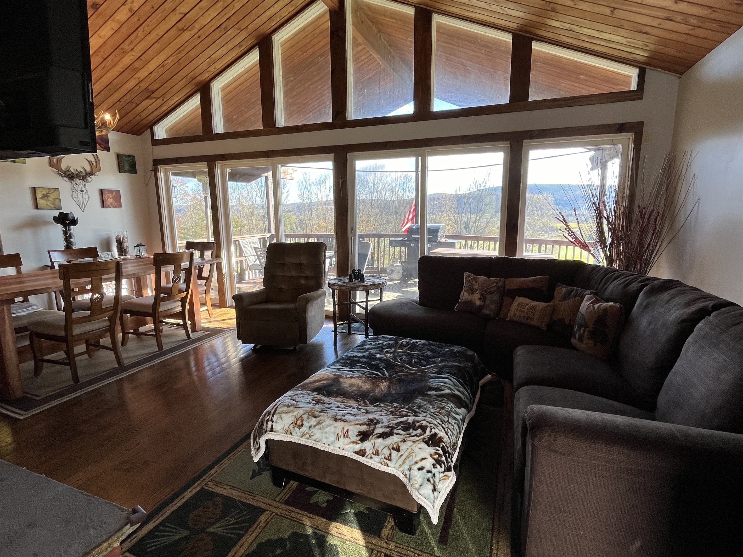 Open living, dining, kitchen with covered deck beyond
