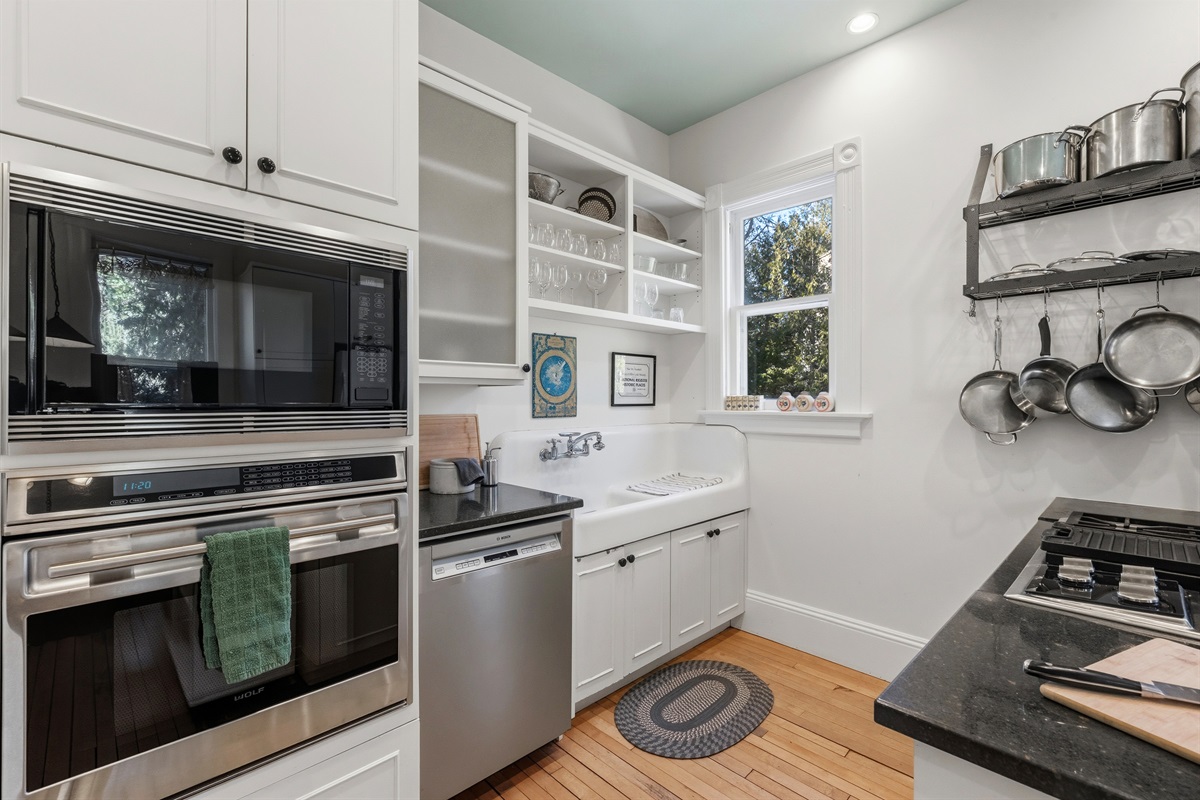 Fully equipped kitchen w/ modern appliances & clean white cabinetry