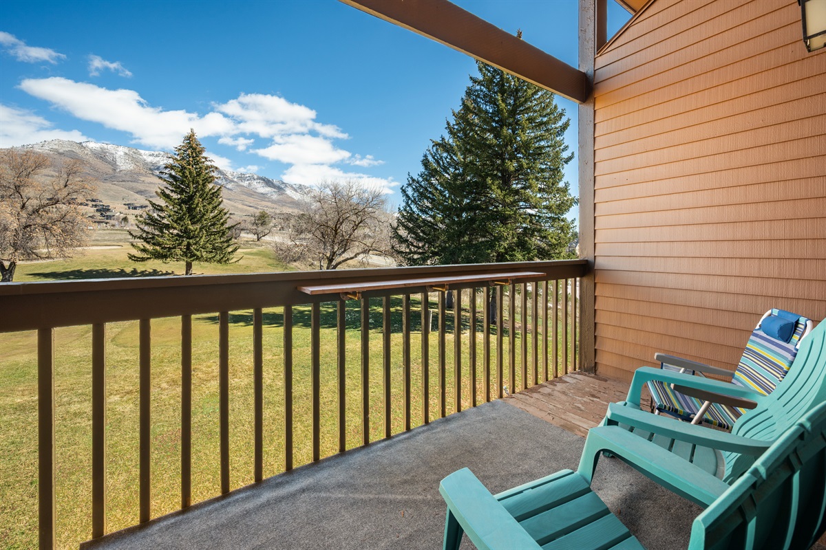 Private balcony with seating and scenic views of the surrounding mountains and golf course.