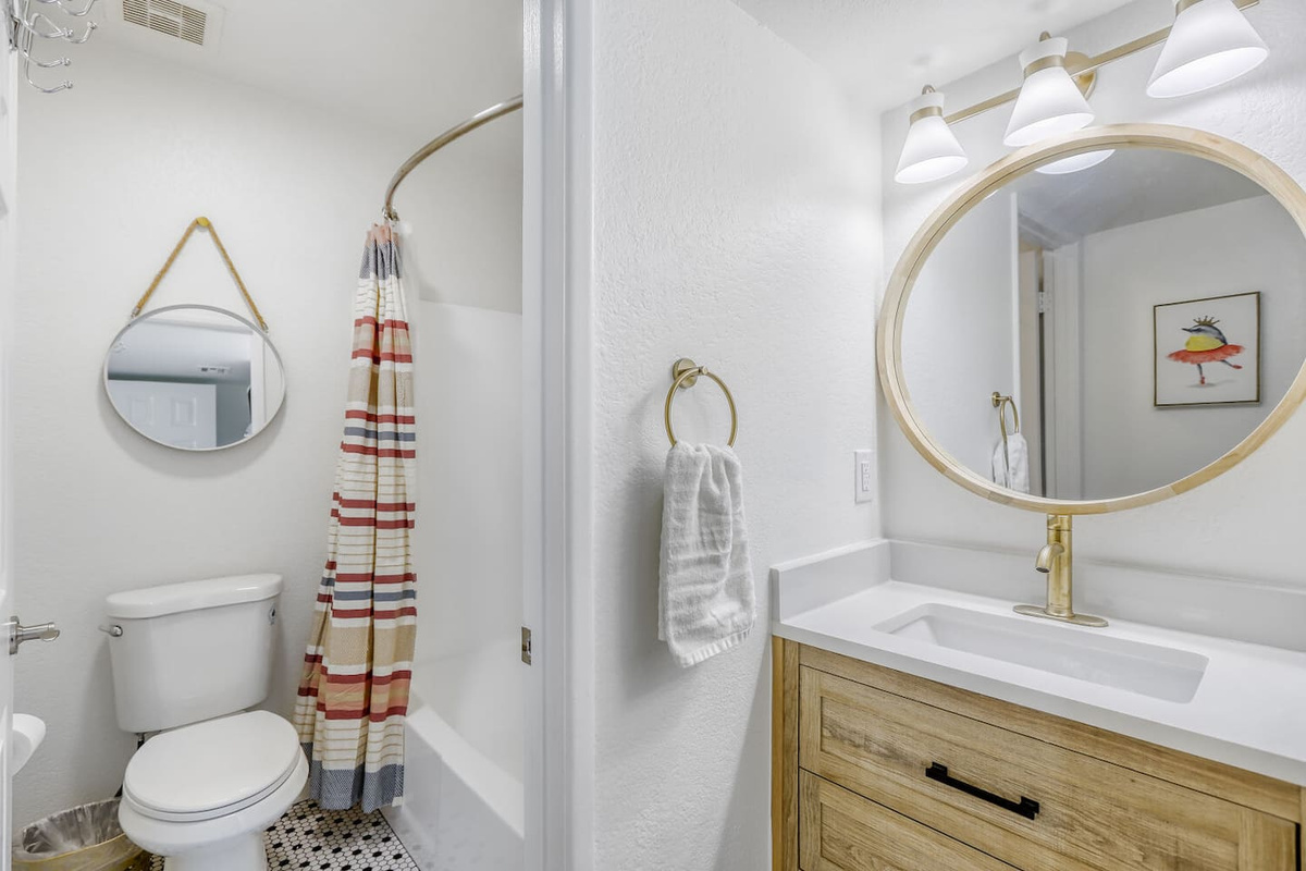 A bright, updated bath with warm brass finishes — ready for a refresh before heading out for the day.