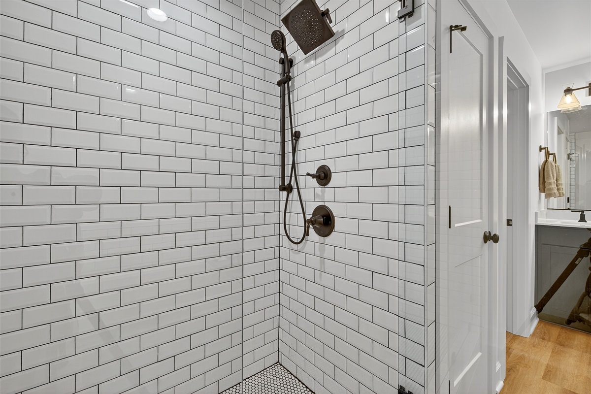 Step into a spacious walk-in shower framed in timeless subway tile, complete with sleek black fixtures for a modern touch.