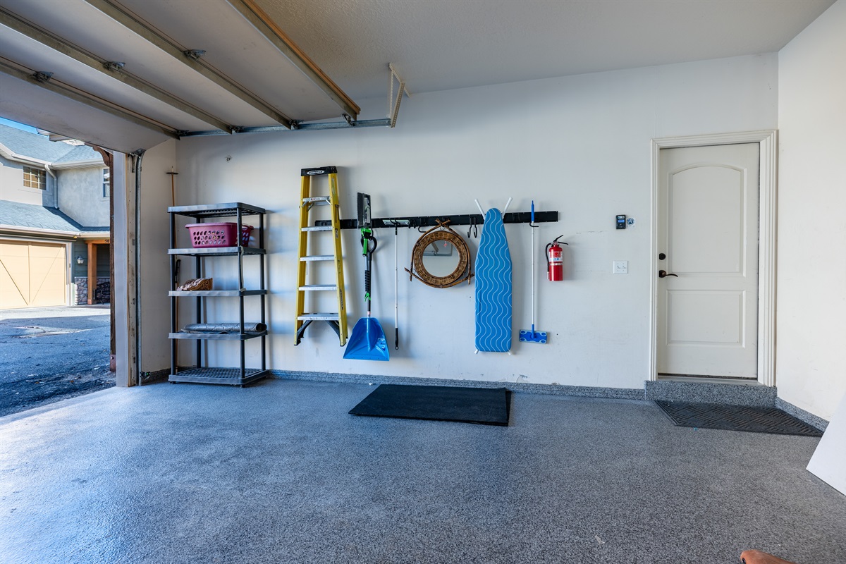 Spacious garage with organized storage area and convenient entry into the home.