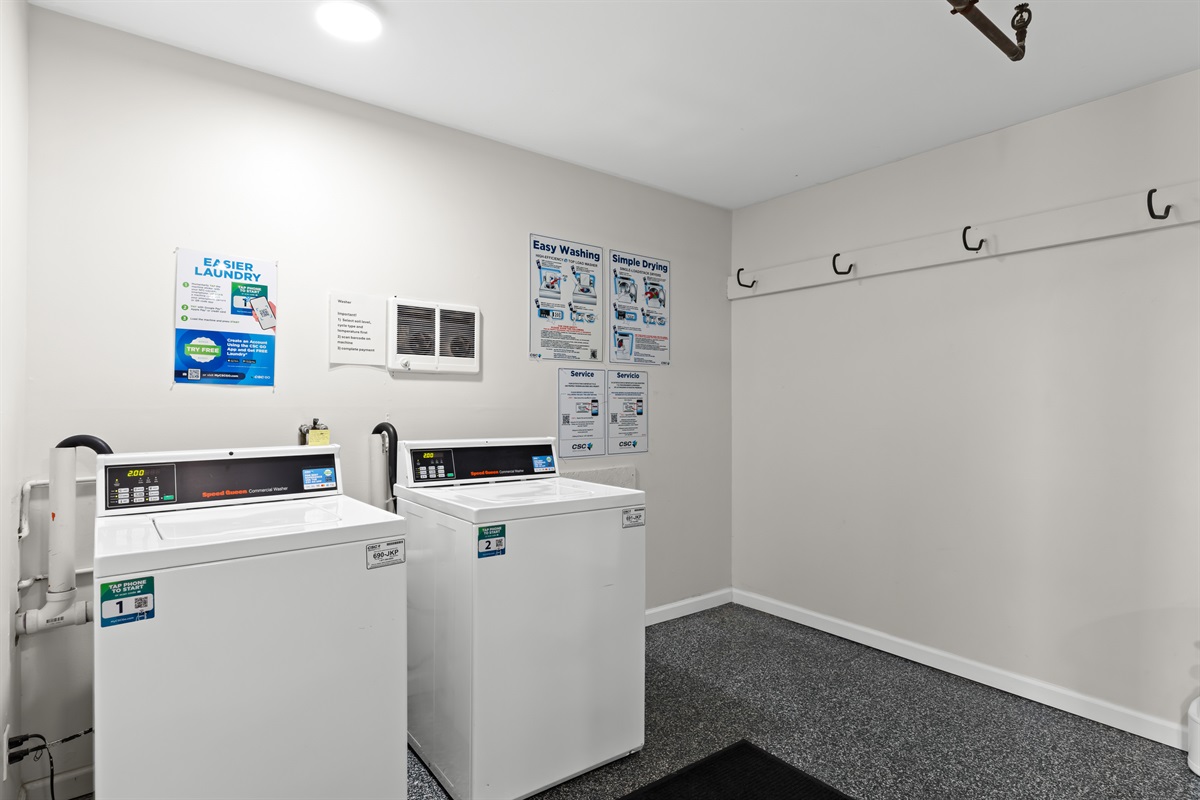 Multiple machines available in the shared laundry room—accepts quarters and digital payment.