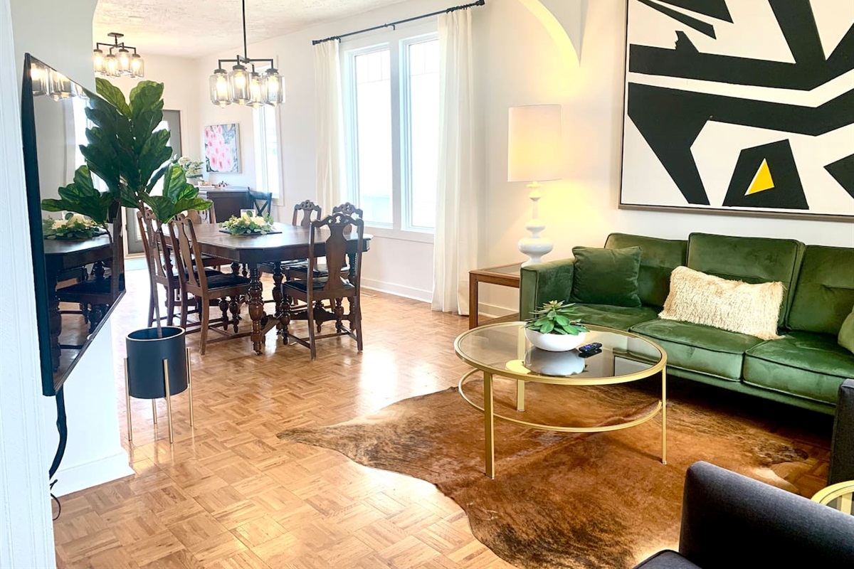 Open concept main-floor living-dining room area. High textured ceilings with tall windows allowing in natural light. 