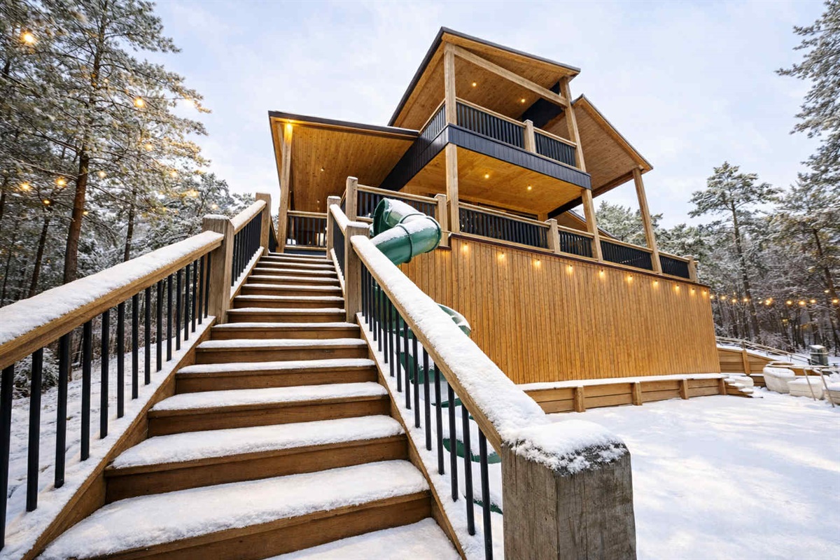 The impressive back deck is the perfect place to sit by the fireplace and stare off into the snow covered forest.