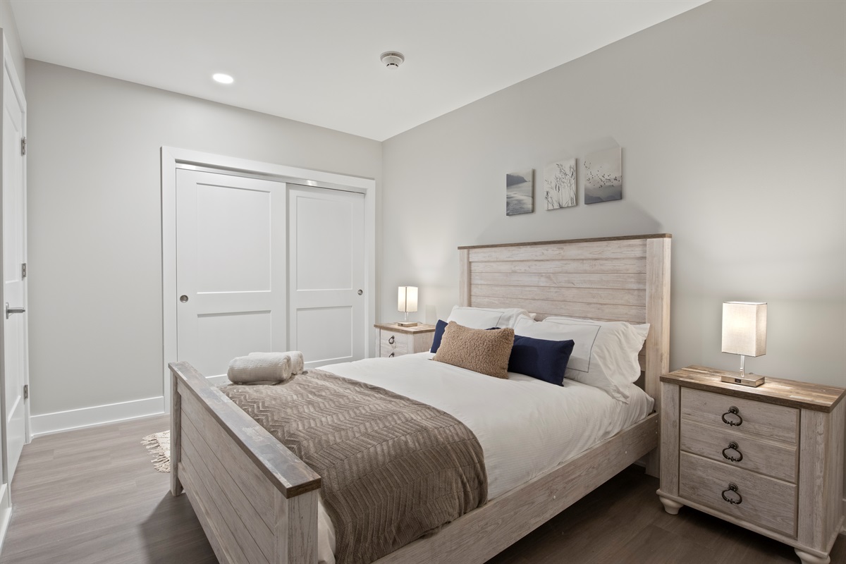 This serene guest room offers comfort and charm with a plush bed, stylish wood furnishings, and ample closet space — ideal for your Finger Lakes getaway.