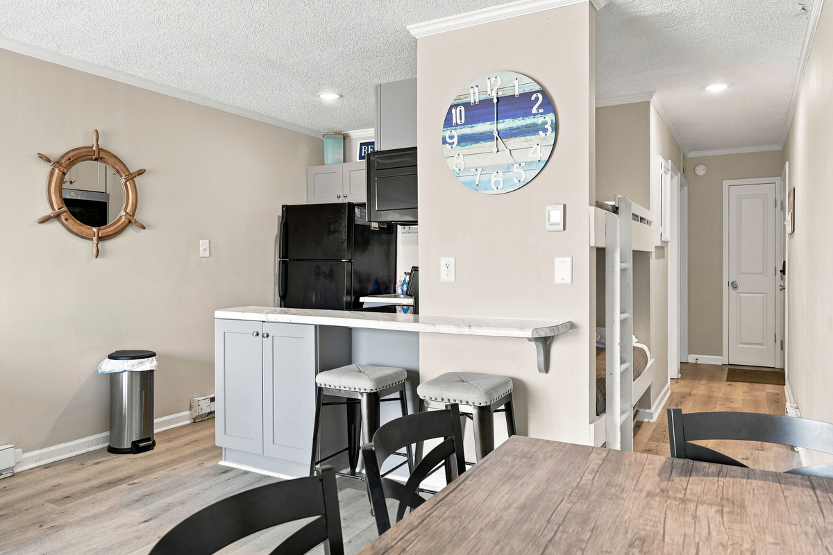 A welcoming space where coastal mornings begin, featuring a bright kitchen, breakfast bar seating, and everything you need for a comfortable island stay