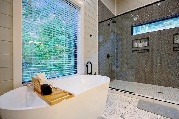 Spa-like bathroom with soaking tub and large window views.