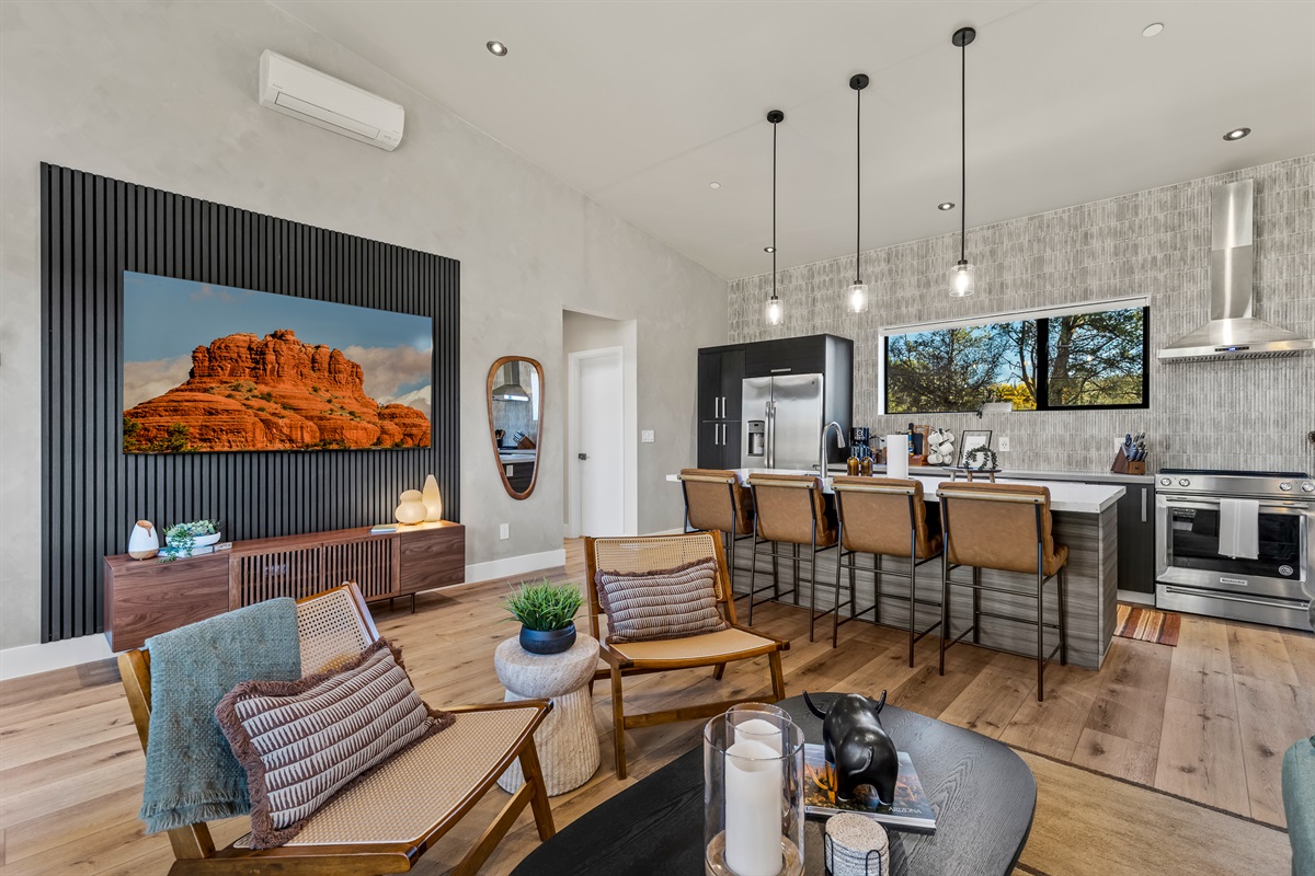 A bright, open-concept living area with comfortable seating, a fully equipped kitchen, and modern finishes - designed for gathering, relaxing, and enjoying time together.