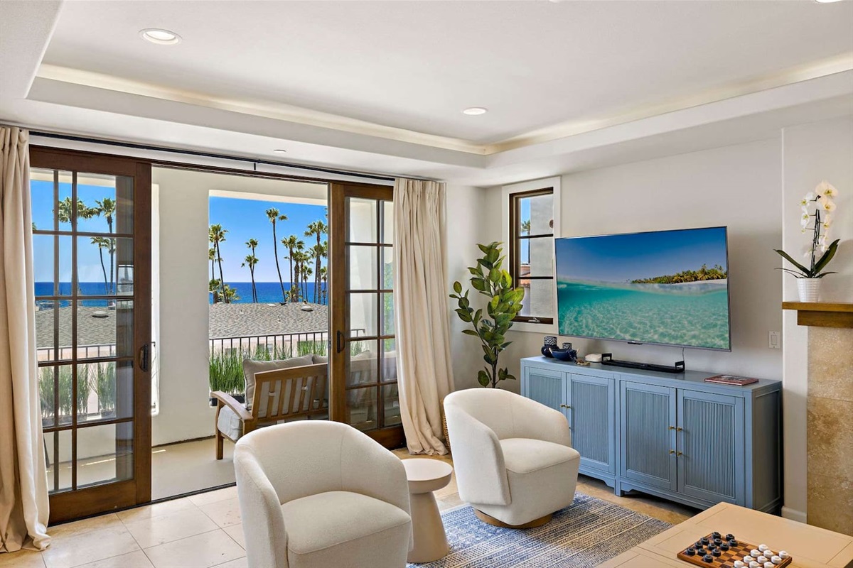 The living room has lots of comfortable seating, views and natural light pouring in from the balcony.