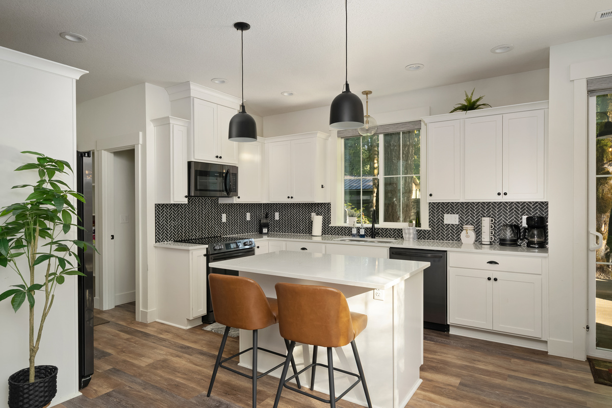 Black herringbone tile and quartz counters — cooking here feels like a treat.