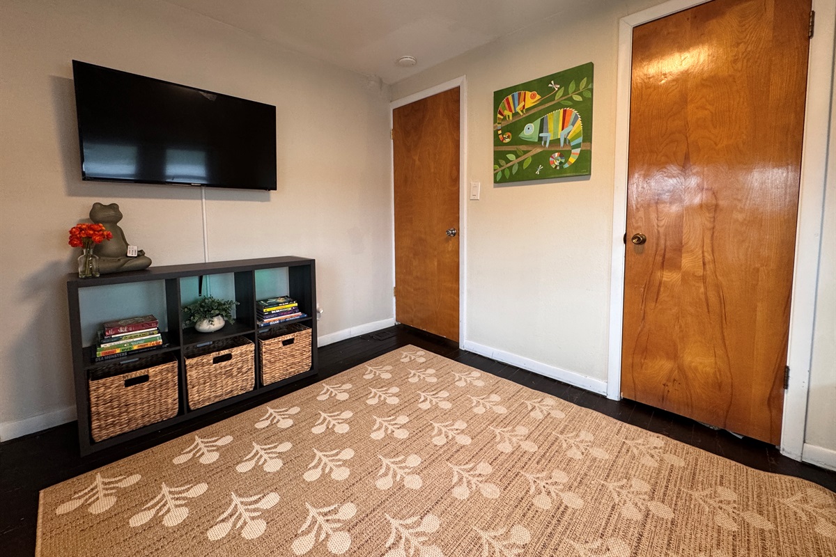 TV and cute backlit cubbies with books and linens for however you want beds set up.