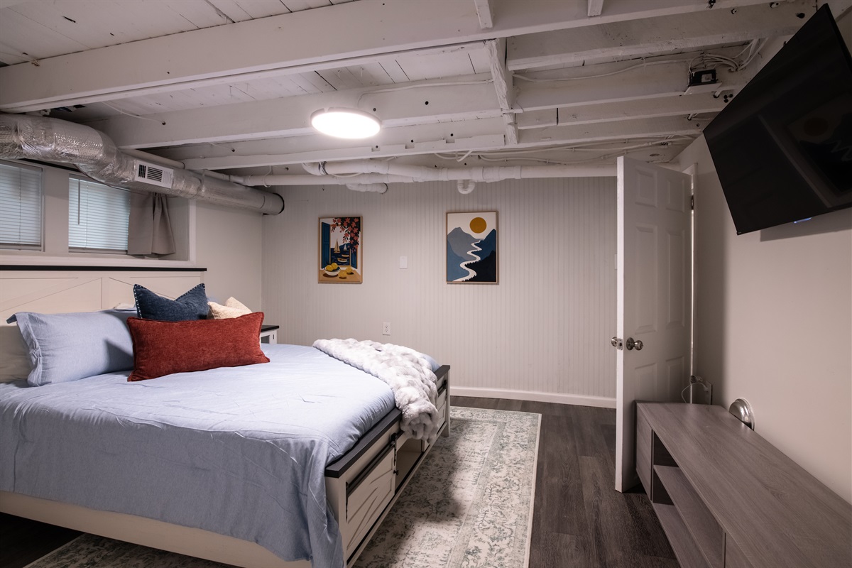 Spacious bedroom with a comfy bed, TV, and stylish décor—ideal for long stays or weekend getaways