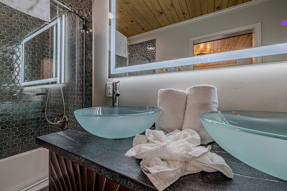 Refresh in style with our sleek double vanity, featuring elegant frosted glass vessel sinks and a contemporary backlit mirror for a spa-like feel.