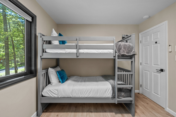Tall windows let in beautiful glimpses of the surrounding Poconos forest while maintaining a bright yet private bedroom atmosphere.