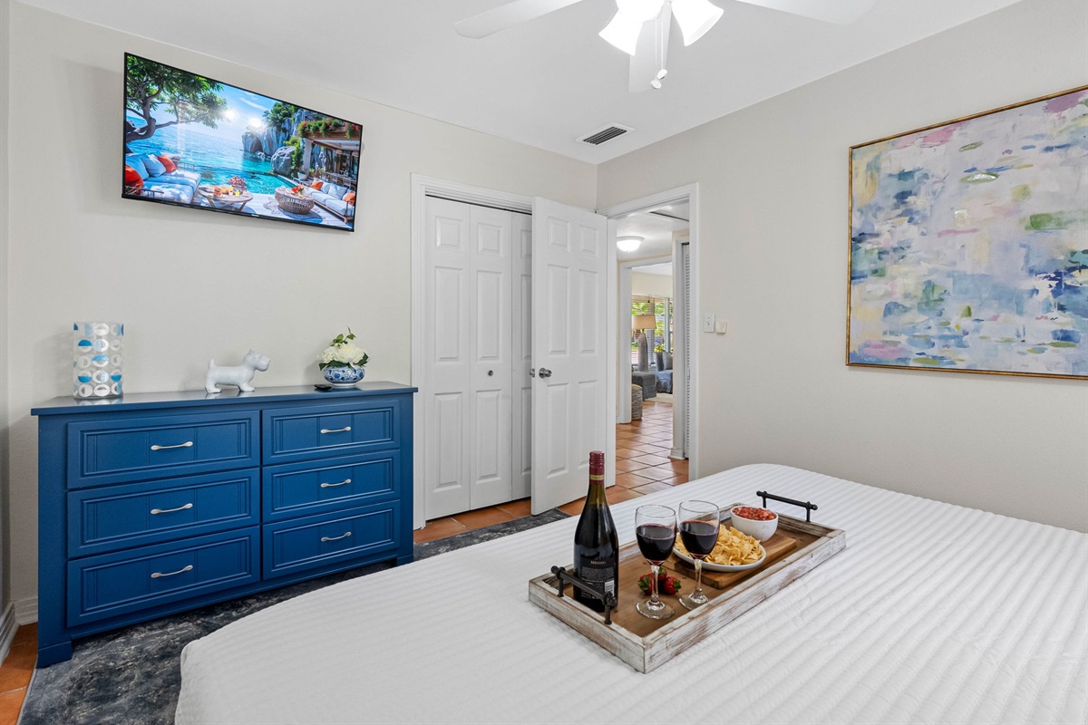 The navy dresser adds a pop of color and storage, while the wall-mounted smart TV lets you enjoy your favorite shows from bed.