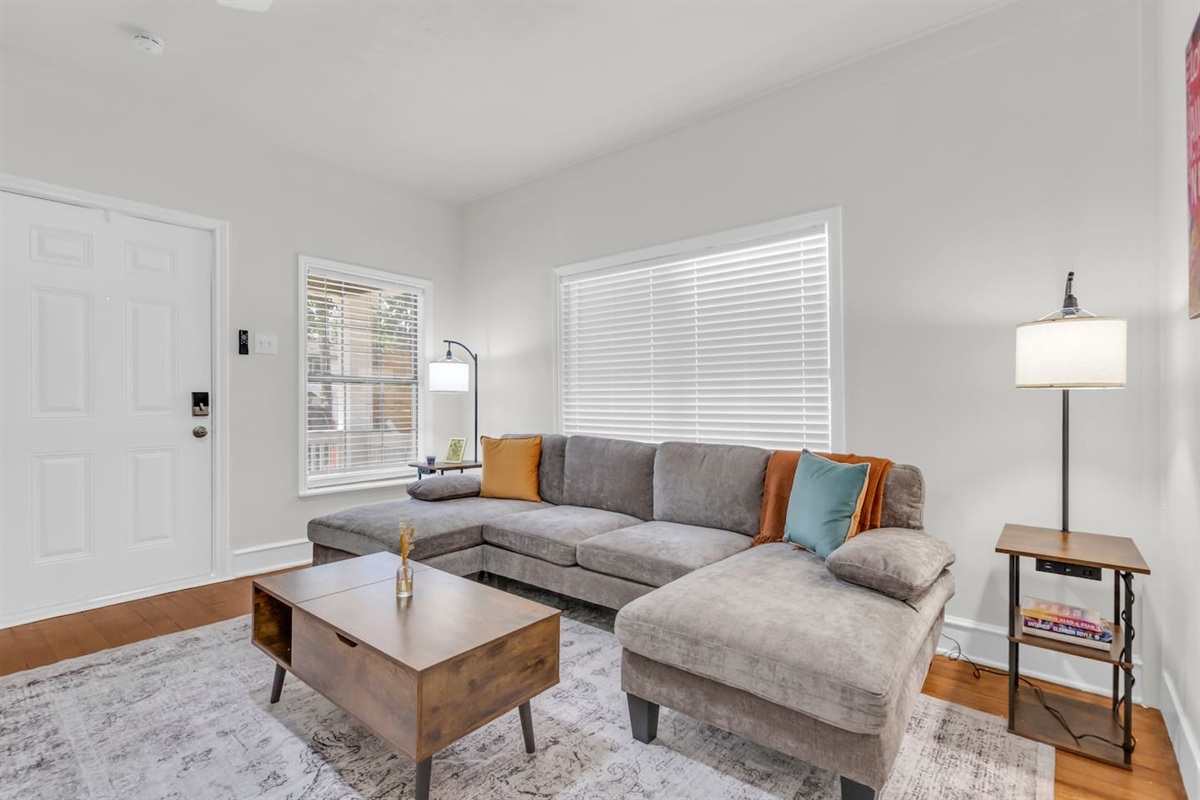 Spacious living room with sectional, wall art, and large coffee table.