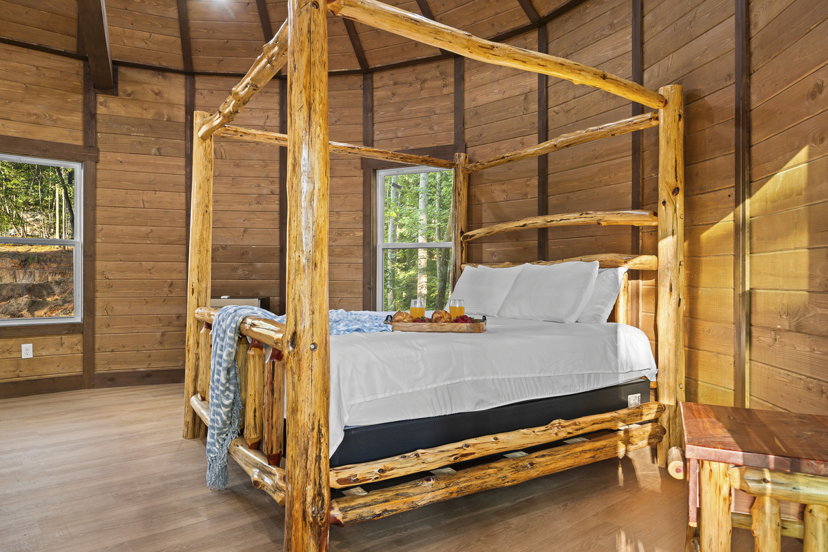 Charming Bedroom Retreat: Rustic canopy bed and woodland views create a serene escape!