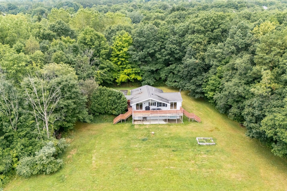 Overhead layout reveals a perfect blend of open green space, shaded woods, and a tranquil pond—all just steps from your door