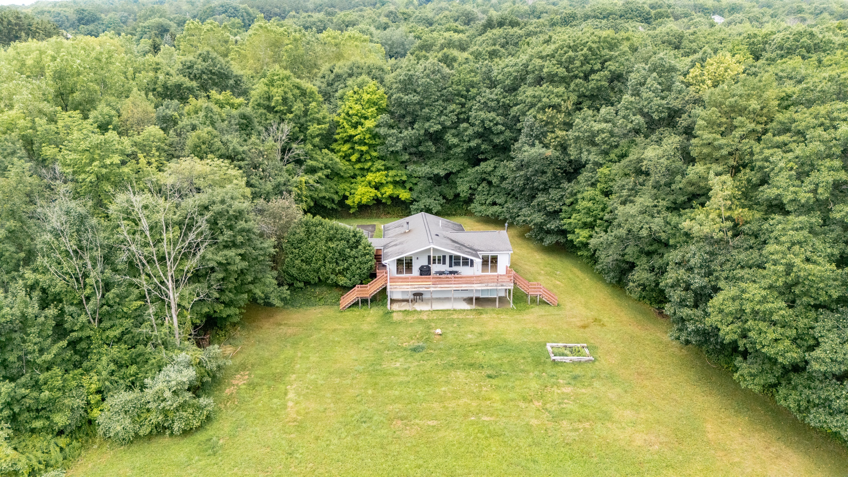Overhead layout reveals a perfect blend of open green space, shaded woods, and a tranquil pond—all just steps from your door