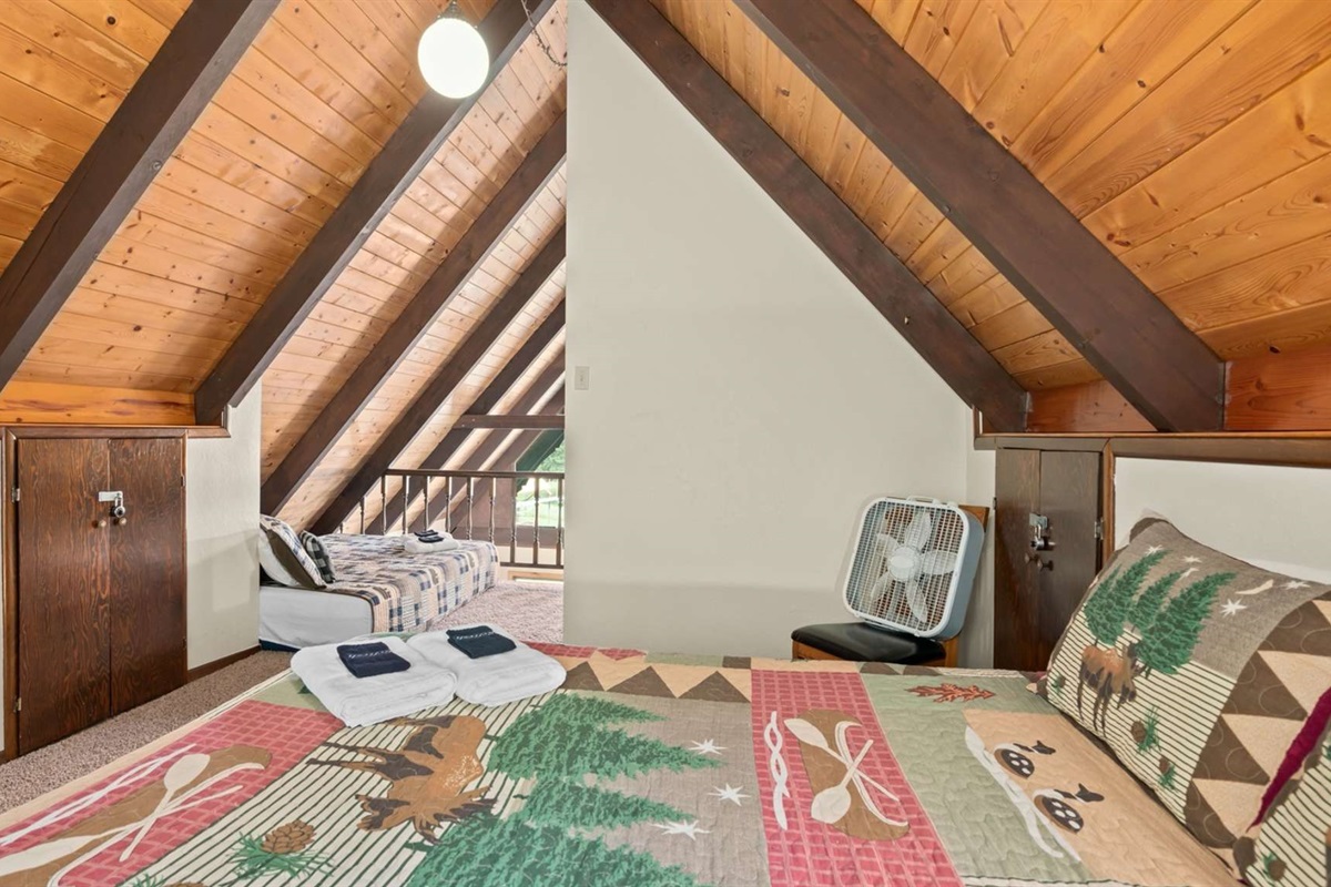 Loft bedroom with queen beds and bright natural light.